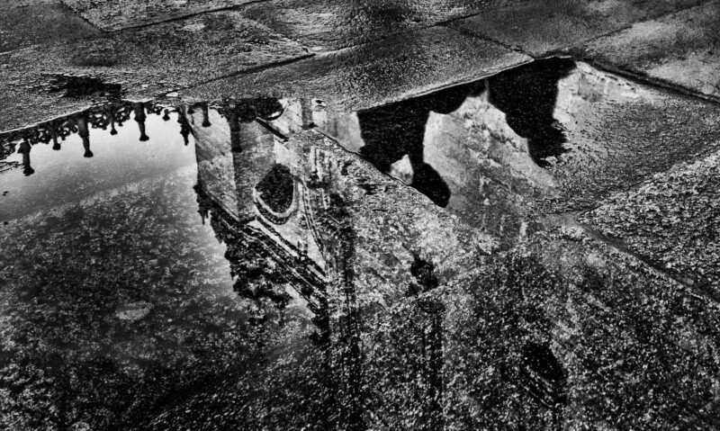 compostela revelada reflejo de la catedral en charco de lluvia