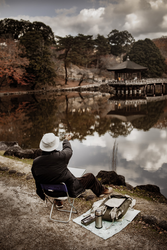 hombre pintando al borde de un lago Japón