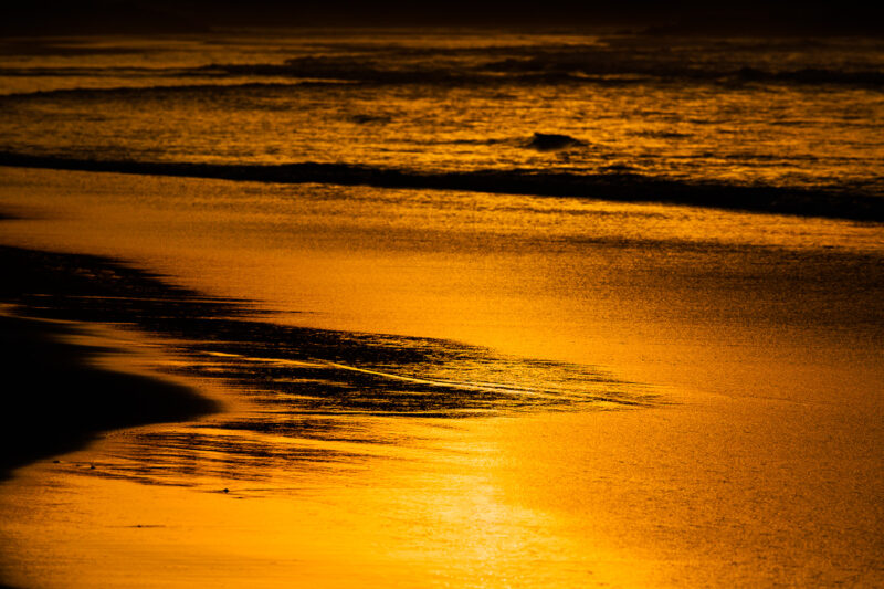reflejo del sol en arena y agua playa