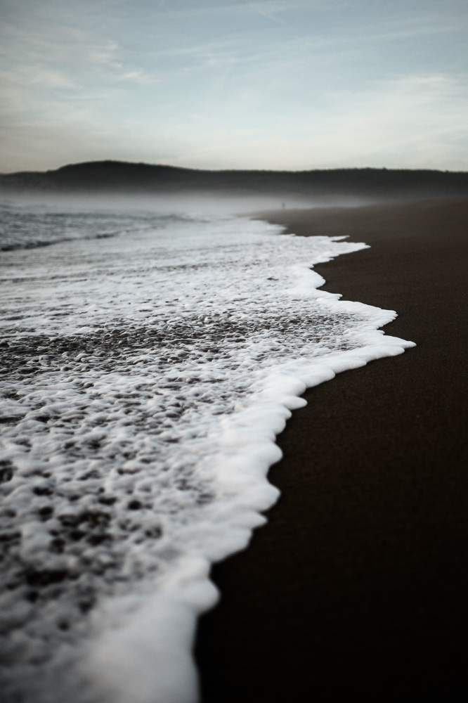 amanecer en playa espuma de olas
